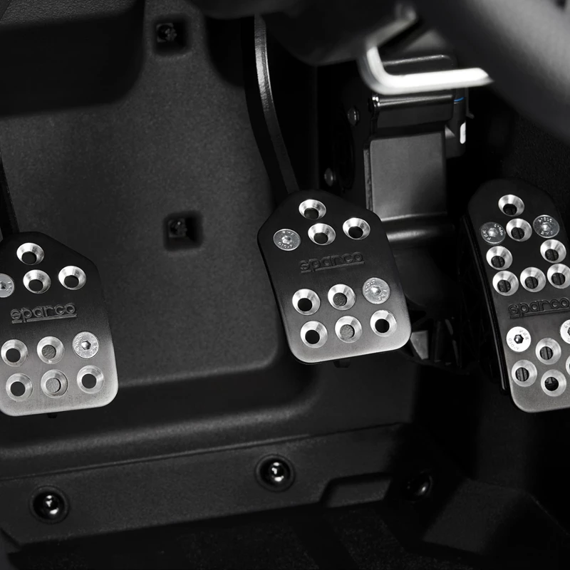 Close-up of three metallic car pedals in a vehicle.