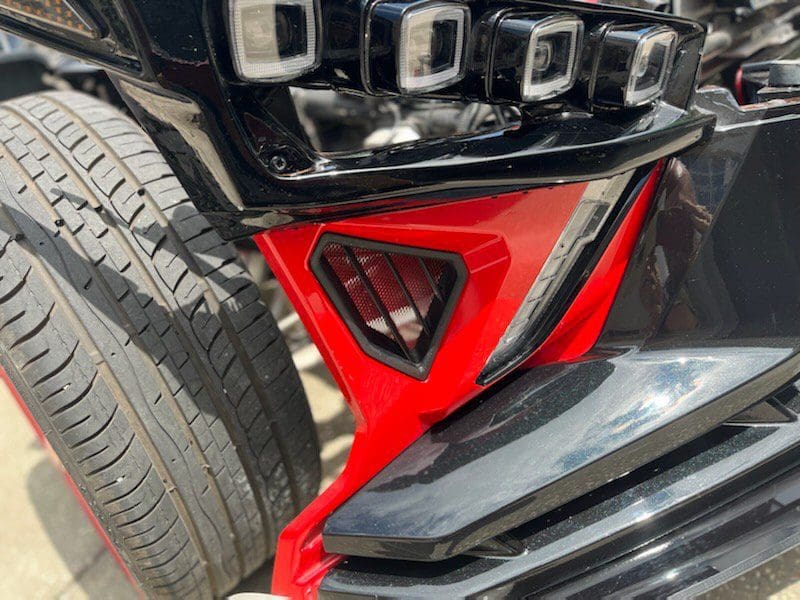 Black and red car bumper with a grill